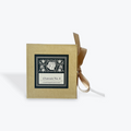 A square kraft paper box with a black and white decorative label reading 'Cheroute No. 4' and a tan ribbon tied in a bow, photographed on a light gray background.