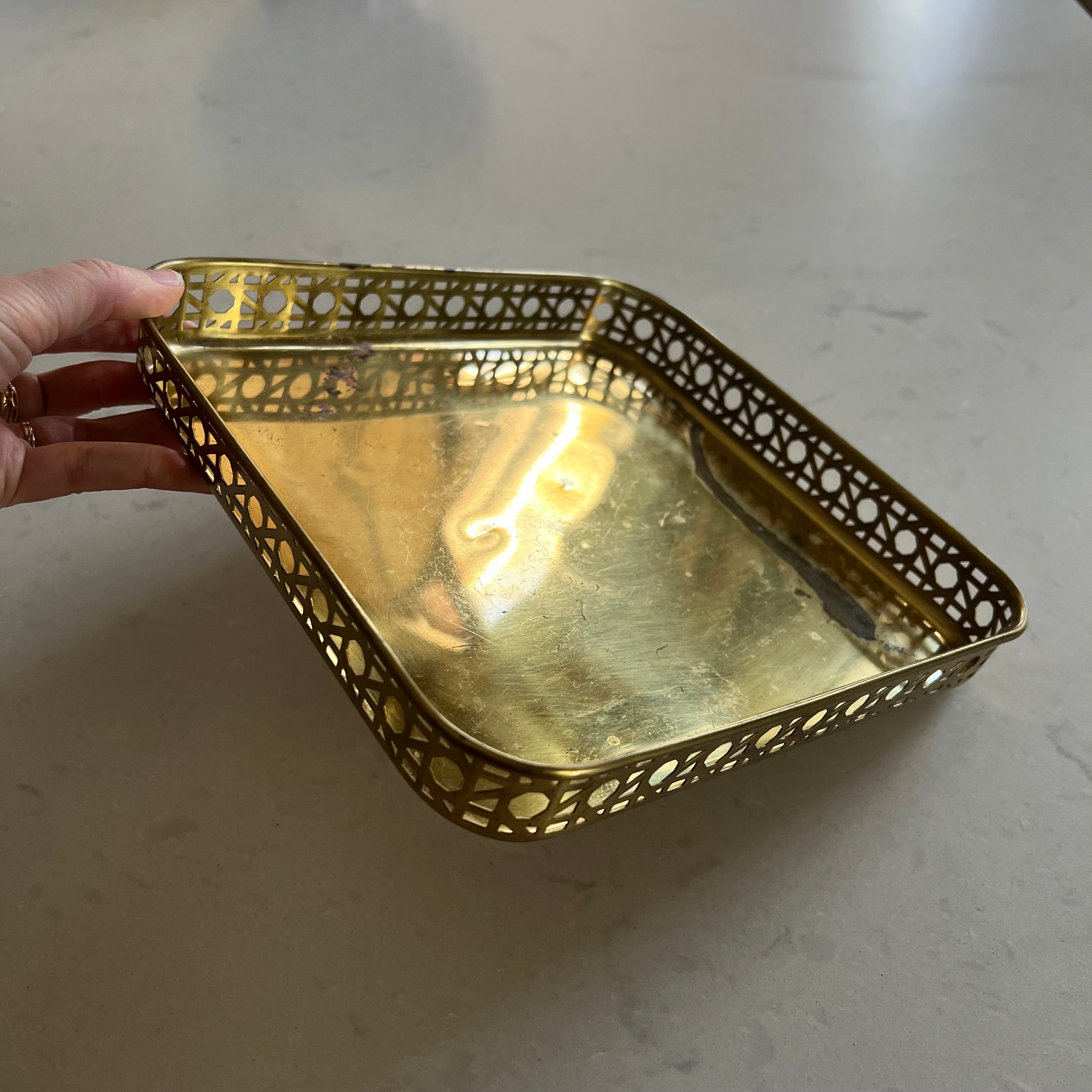 Gold decorative tray held by a hand on a light background