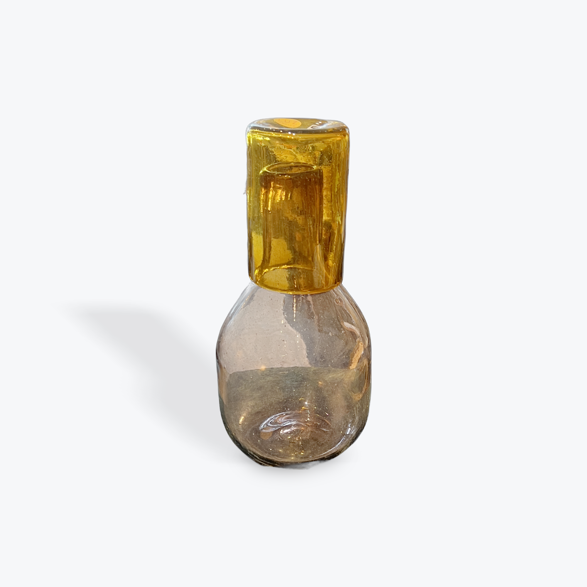 Light pink glass carafe with amber-colored glass on a white background