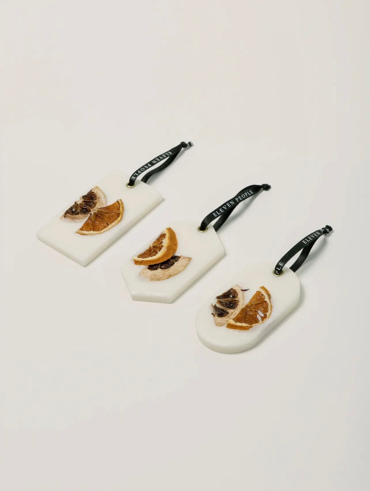 Three wax bars with dried orange slices  on a light gray background.