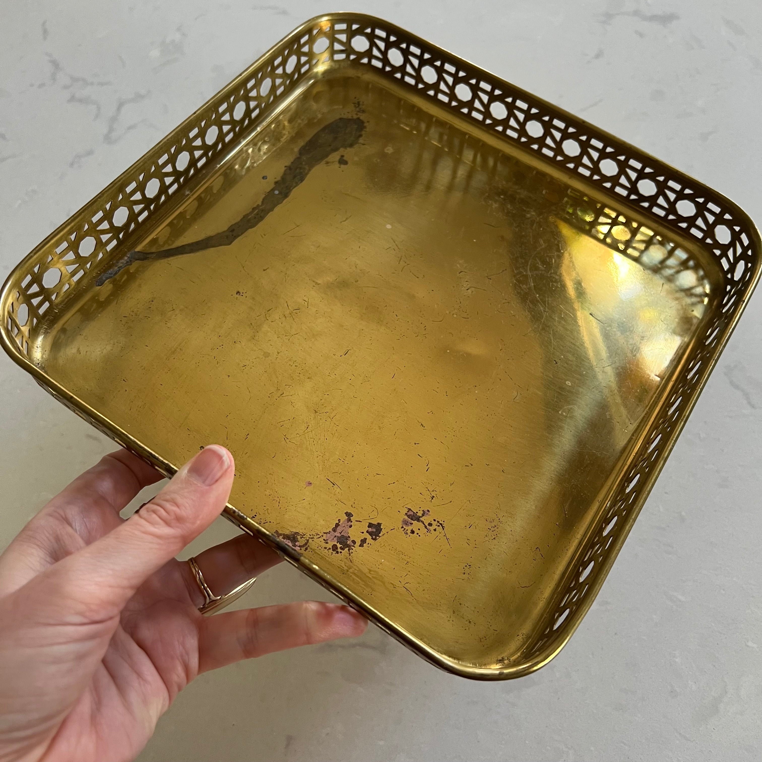 Gold decorative tray held by a hand on a light background