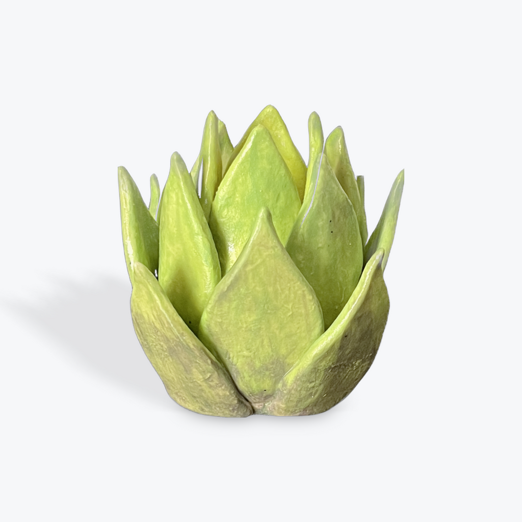 Green ceramic artichoke-like candlestick on a white background