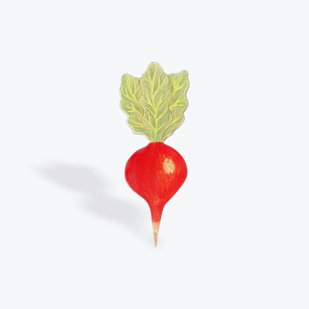 Red ceramic radish with green leaf on a white background