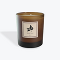 Brown candle with a label featuring a basil leaf design on a white background