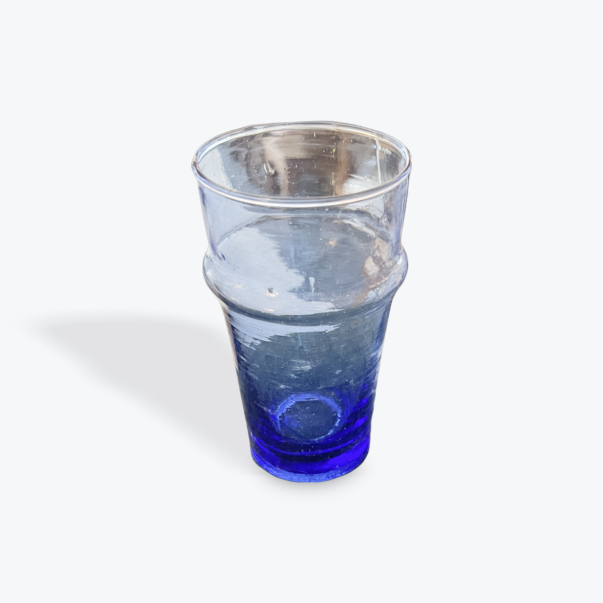 Blue recycled drinking glass on a white background