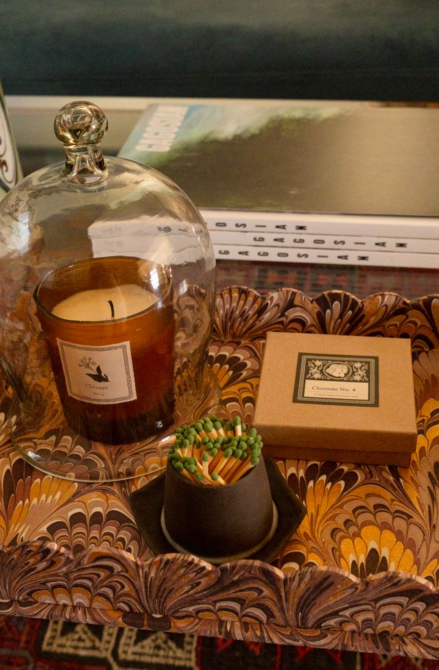 Candle under a glass dome with match strike and box a on a marbled tray