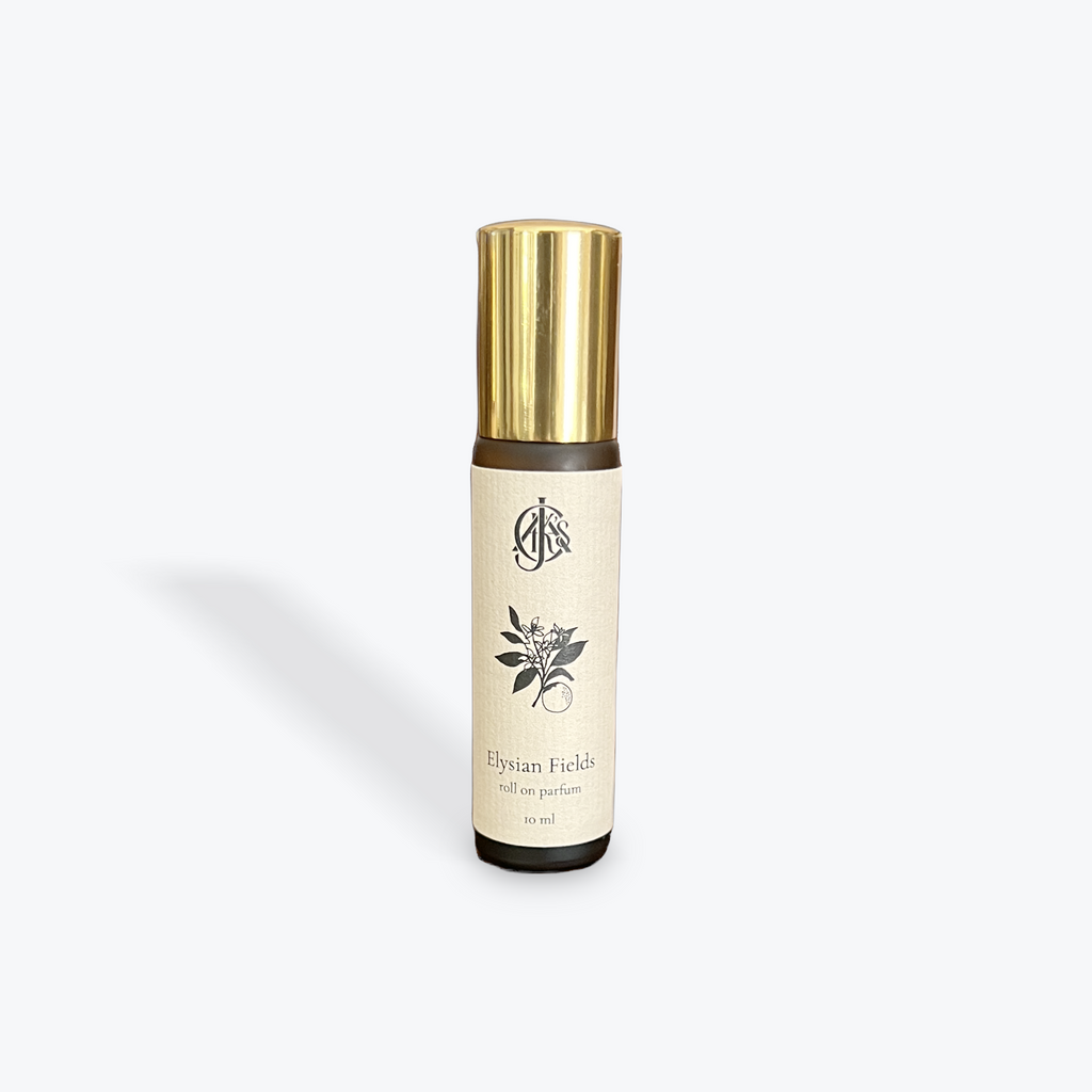 Roll on parfum bottle with gold cap and beige label on a white background