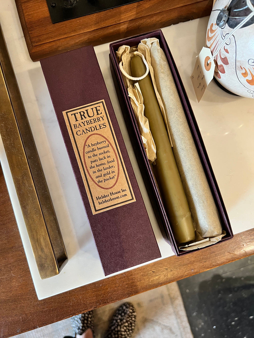Bayberry candle in a decorative box with a label on a wooden surface.