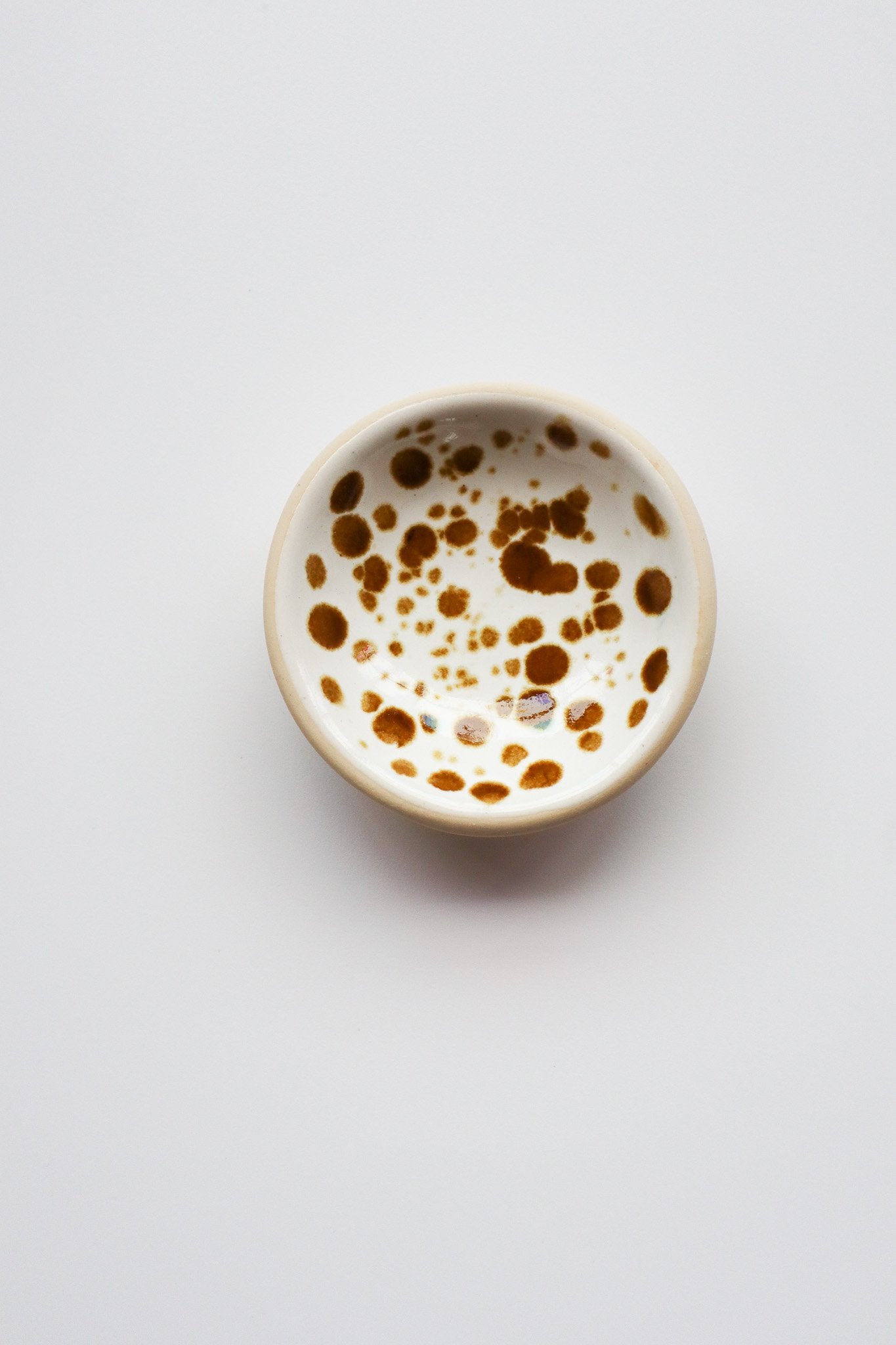 Small ceramic bowl with brown speckles on a light gray background