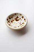 Small ceramic bowl with brown speckles on a white background