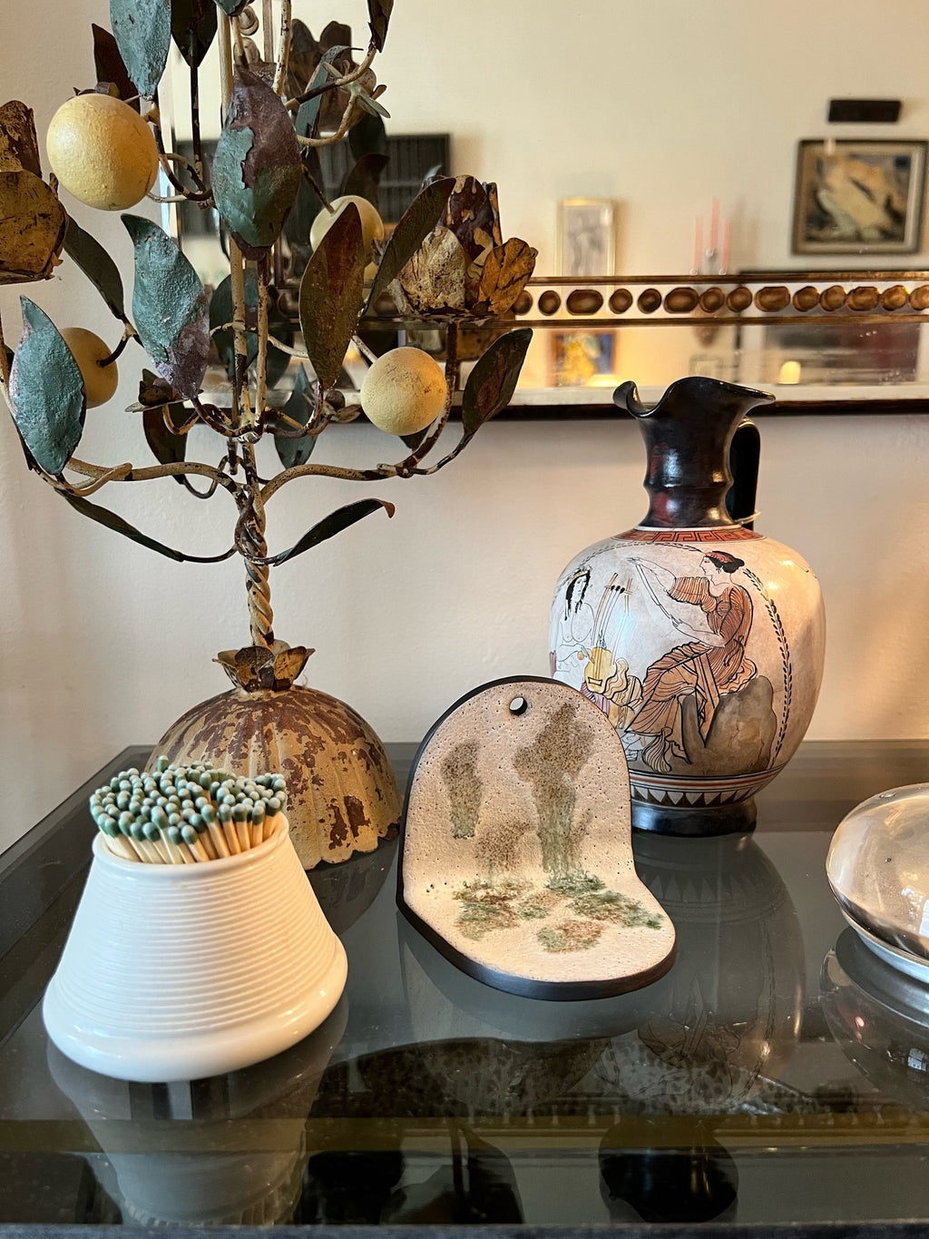 Decorative items including a candelabra, vase, and small table with a mirror in the background.