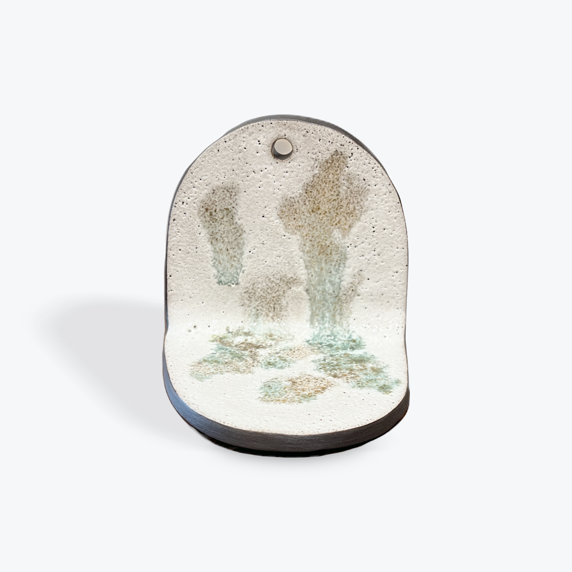 Decorative ceramic piece with light green splotches on a white background