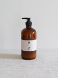 Brown bottle with pump and white label on a light gray background