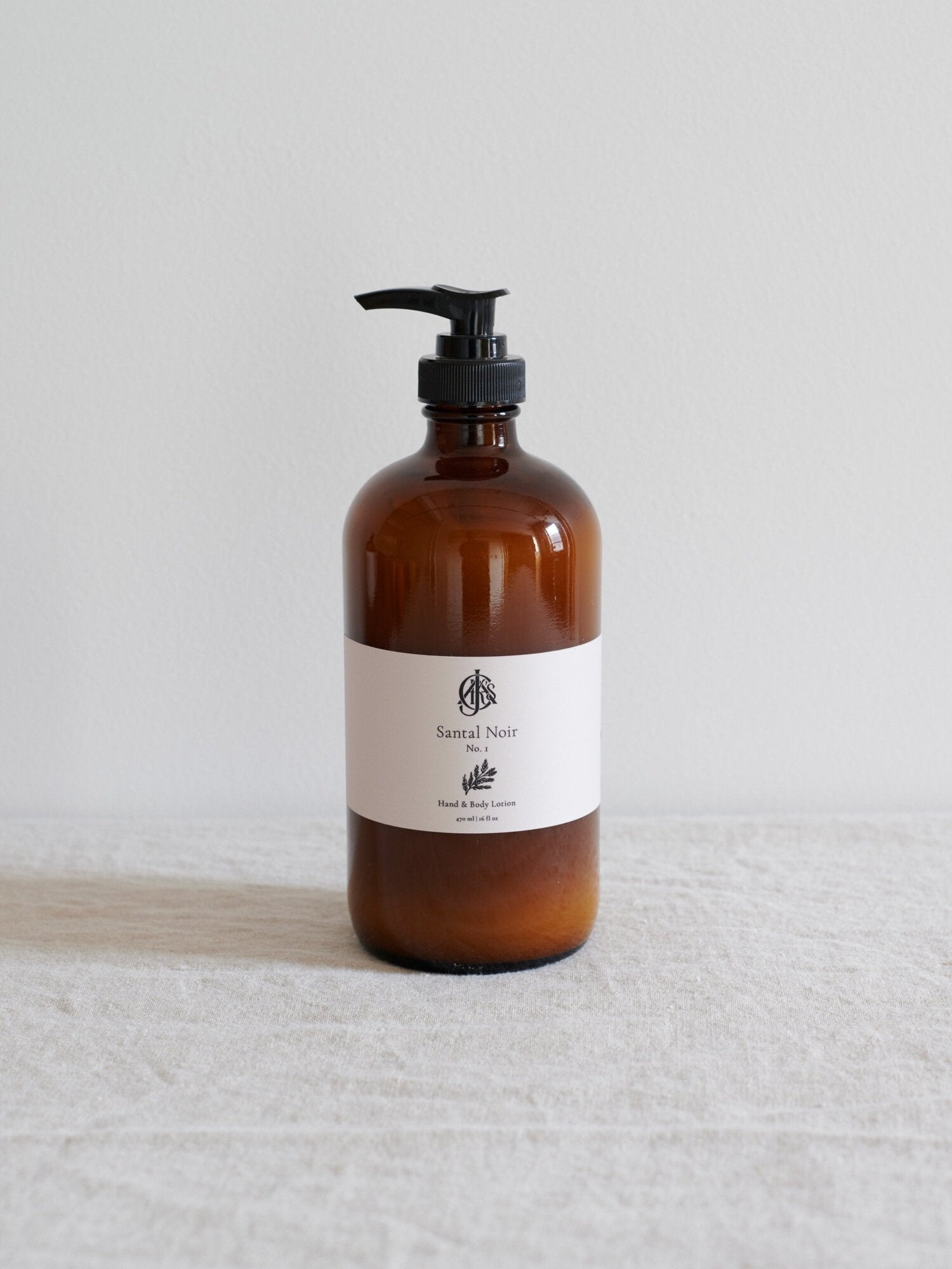 Brown bottle with pump and white label on a light gray background