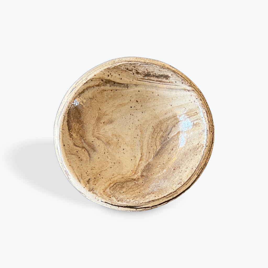 Round ceramic dish with marbled design on a white background