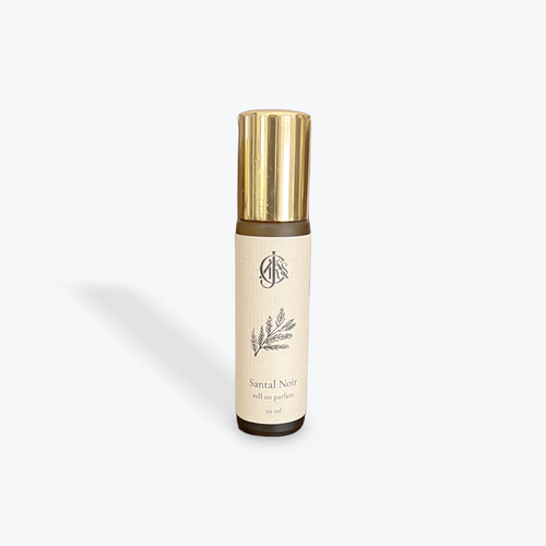 Perfume bottle with gold cap and beige label on a white background