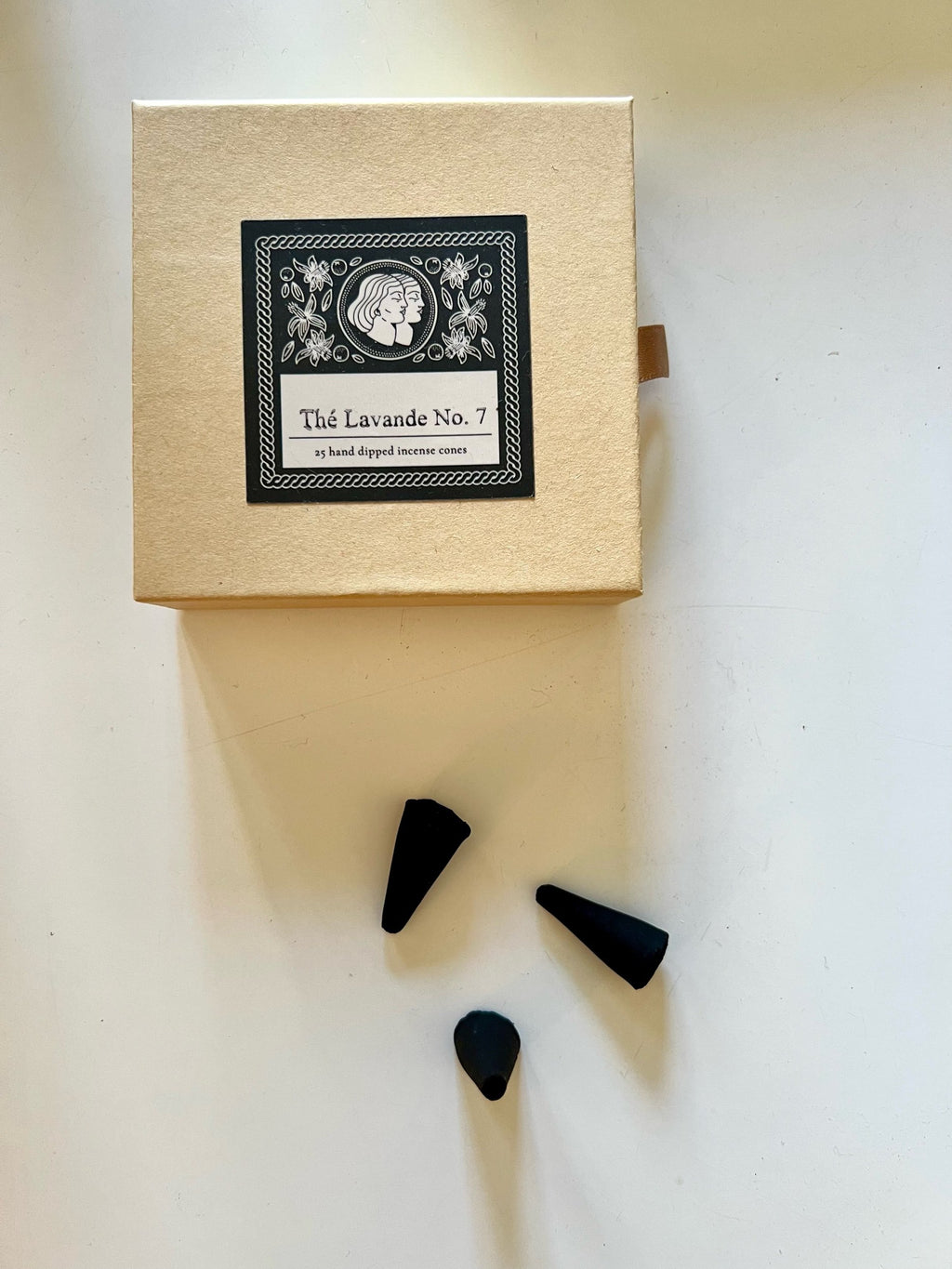 Black incense cones with a decorative box on a white background