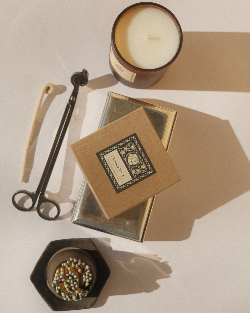 Candle, books, and decorative items on a neutral background