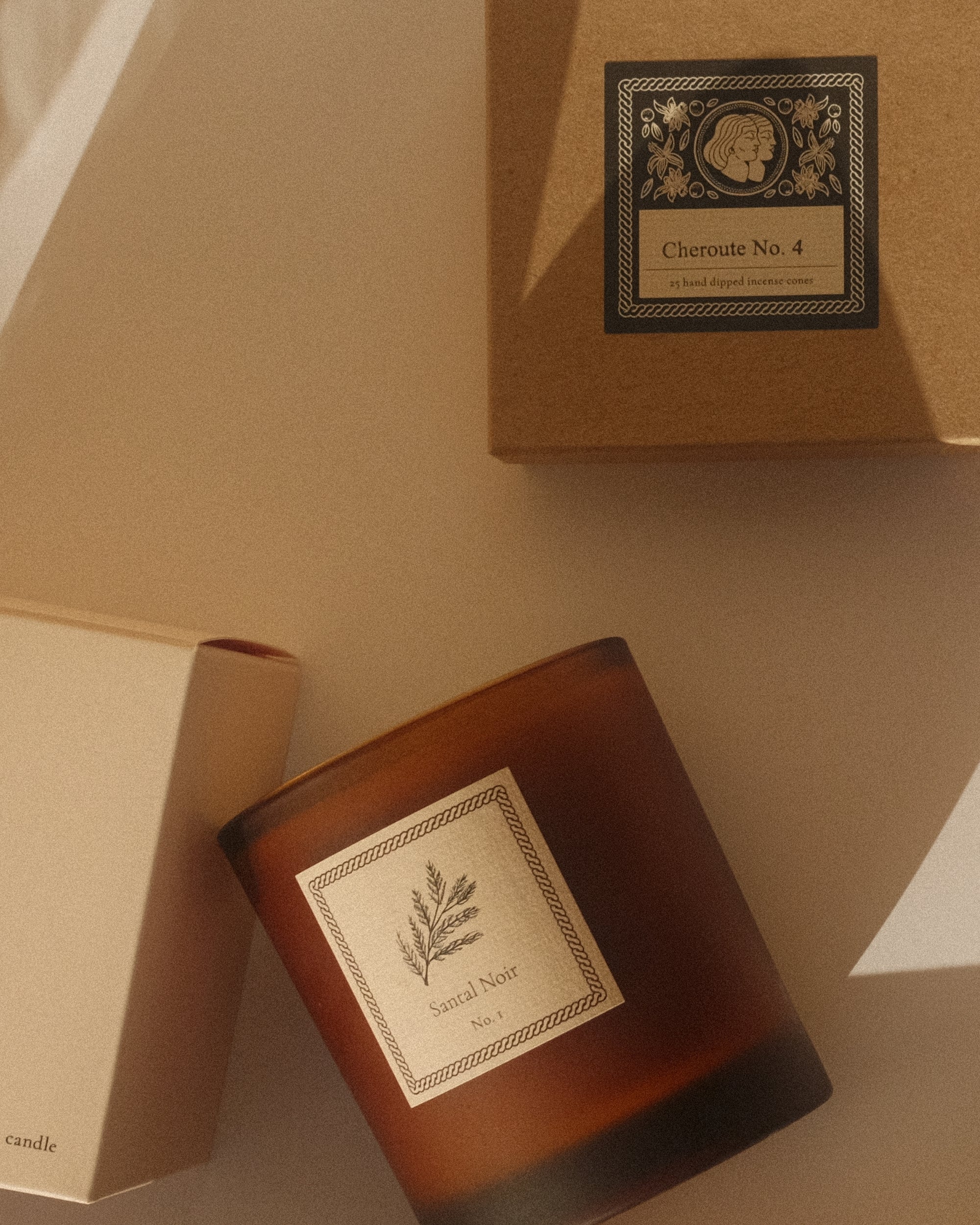 Amber candle and incense box with Jack's Daughters branding on a beige surface.