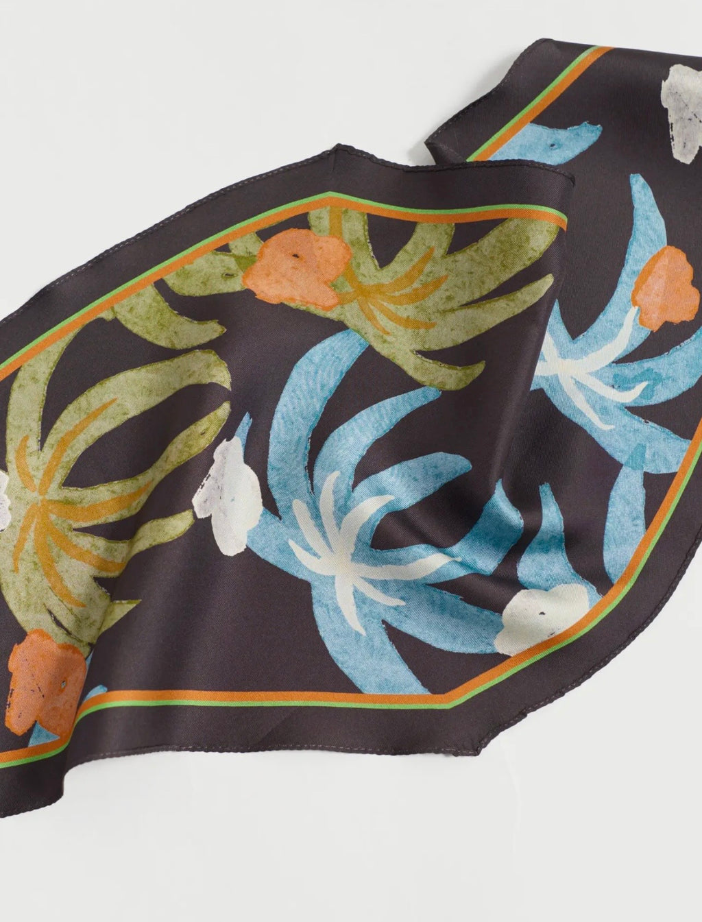 Silk scarf with tropical leaf design on a white background
