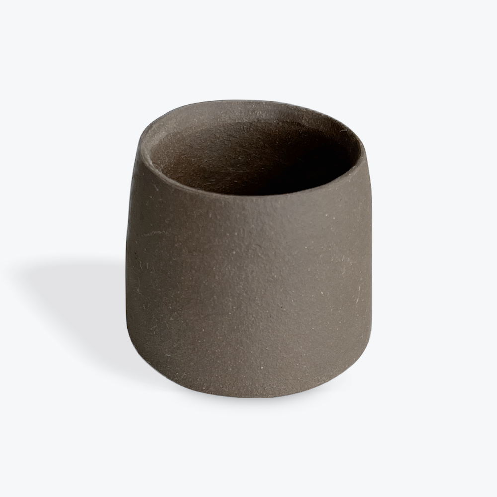 Dark brown ceramic match striker on a white background