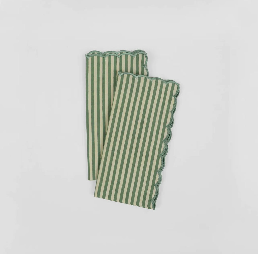 Pair of green and white stripe napkins with scalloped edge on a white background.