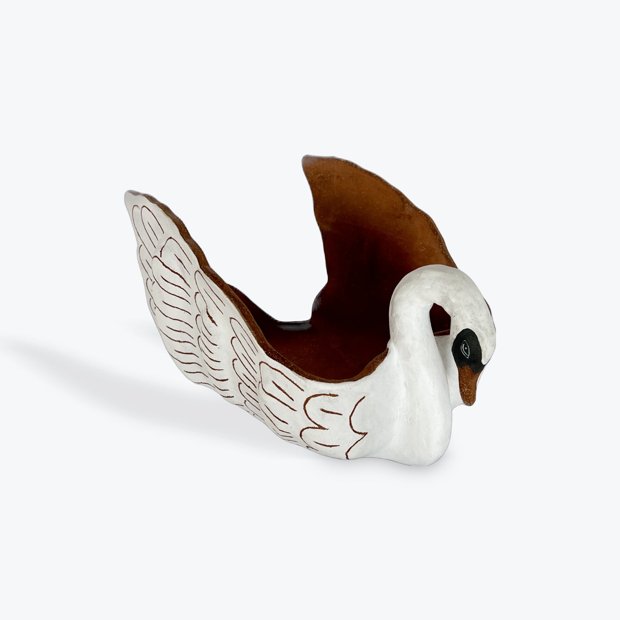 White ceramic swan figurine with brown beak on a white background