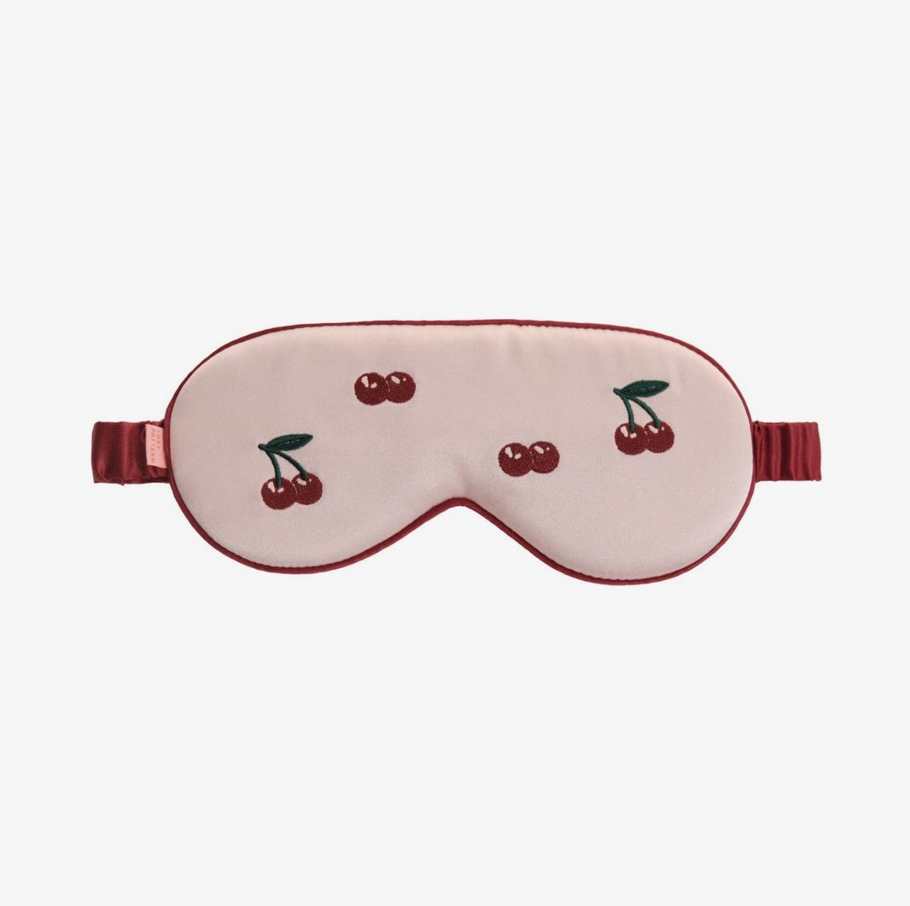 Sleep mask with cherry design on a white background