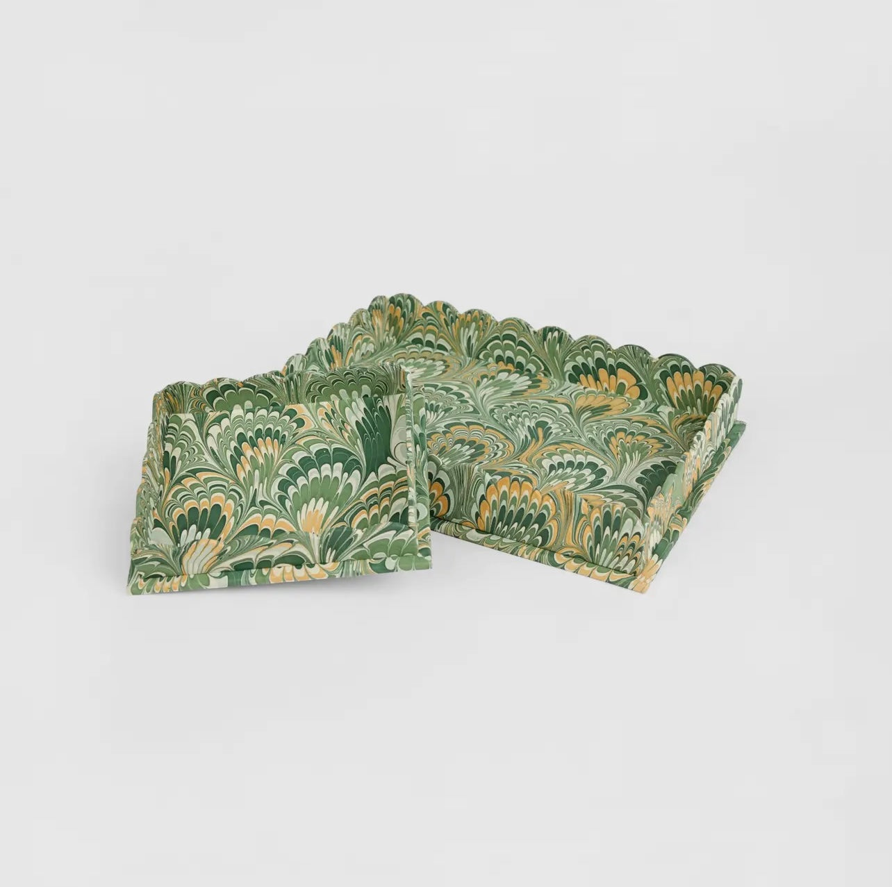 Two green marbled trays with scallop edge on a white background