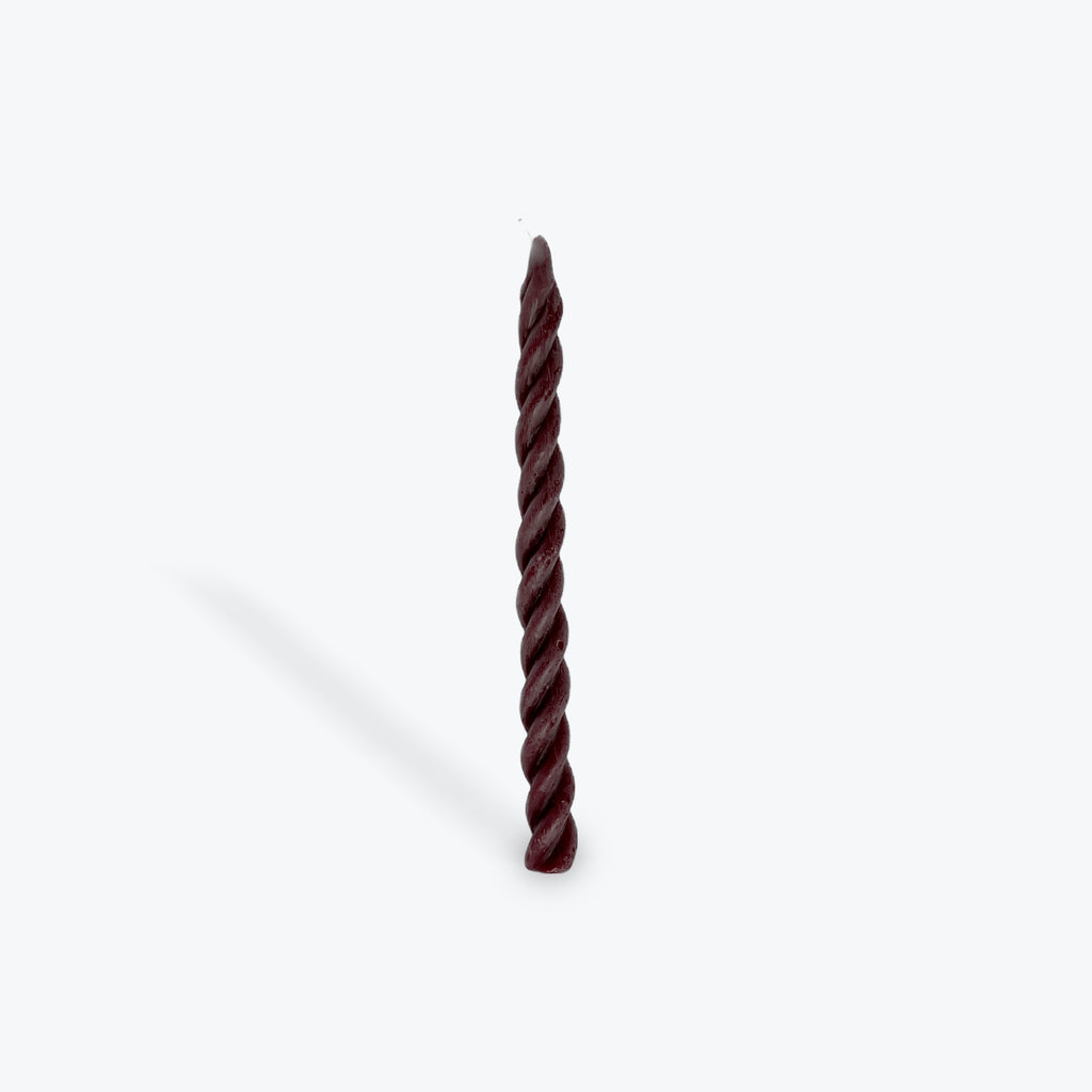Twisted plum taper candle on a white background