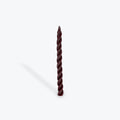 Twisted plum taper candle on a white background