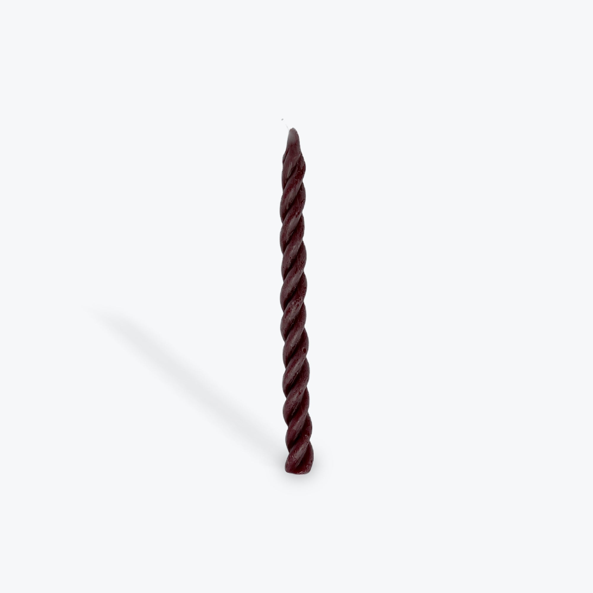 Twisted plum taper candle on a white background