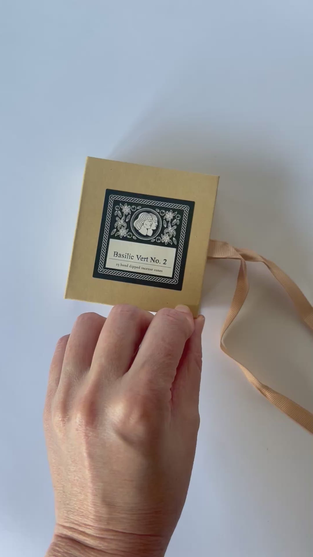 A short video showing a hand opening a kraft incense box with ribbon. 