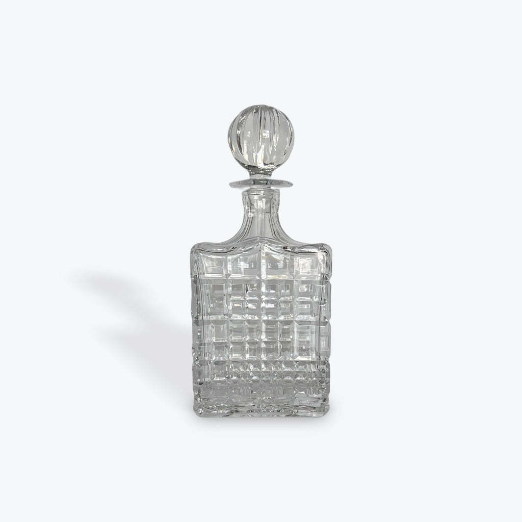 Clear crystal decanter with a  stopper on a white background
