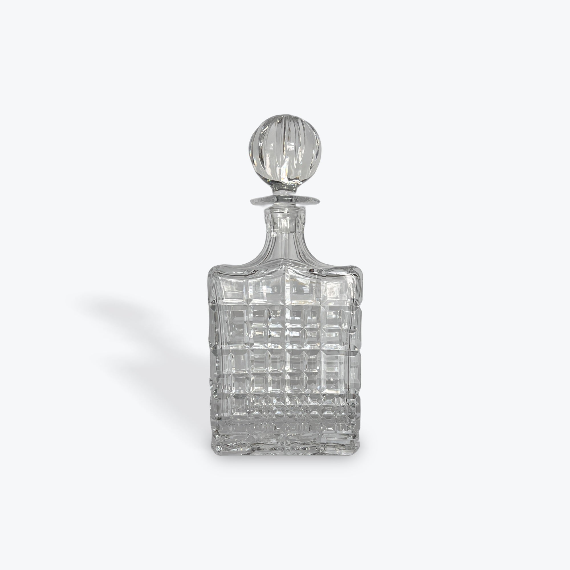 Clear crystal decanter with a  stopper on a white background