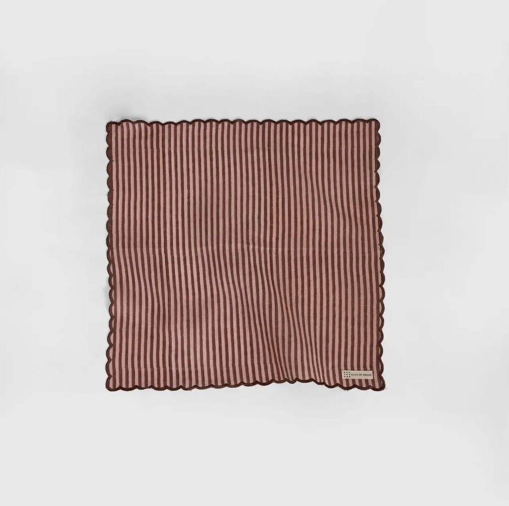A stripe rose and brown napkin with a scalloped edge on a white background