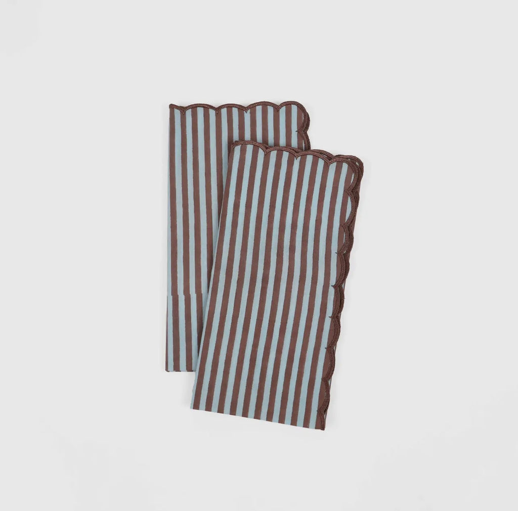 Pair of blue and brown stripe napkin with scalloped edge on a white background. 