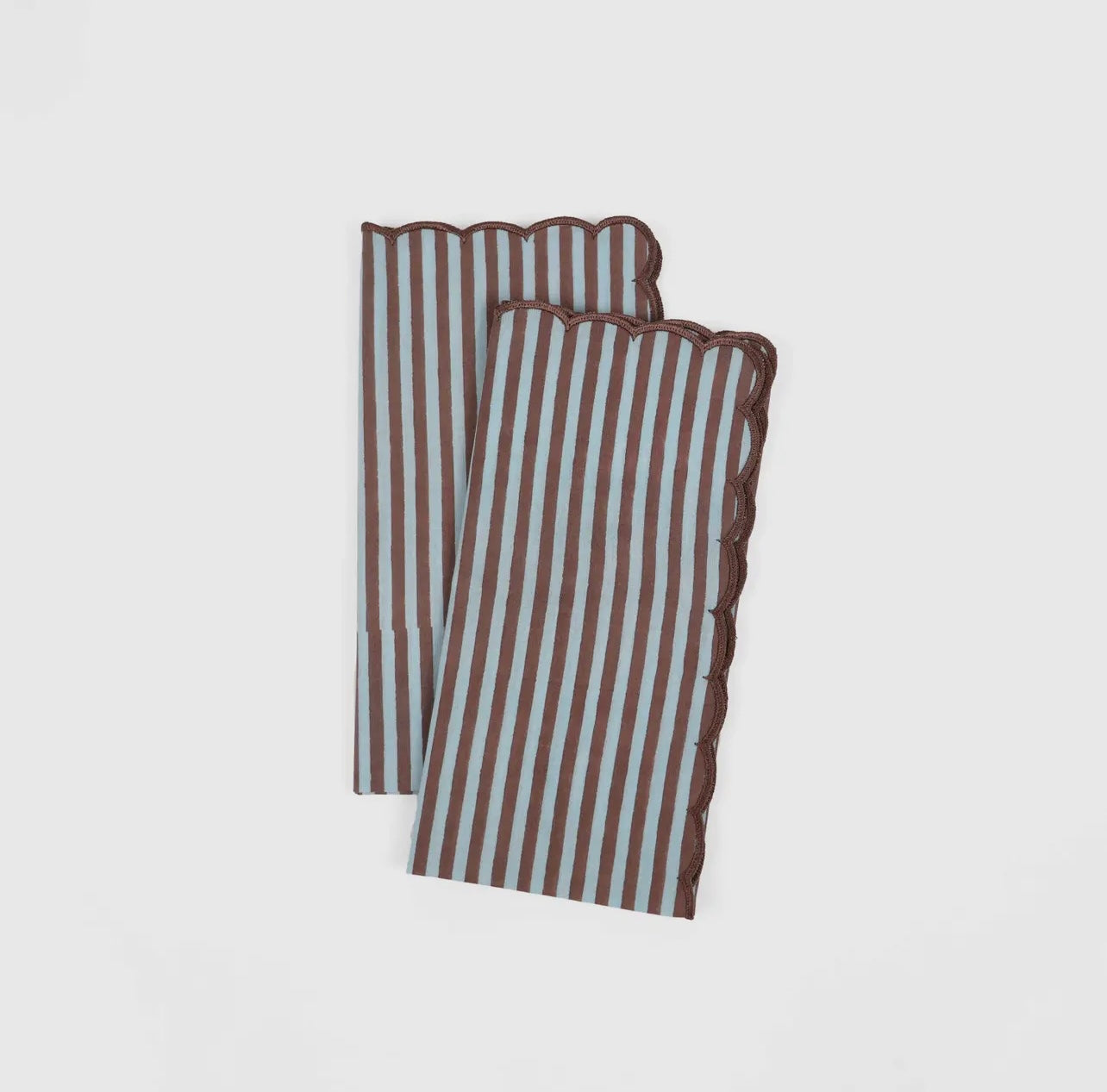 Pair of blue and brown stripe napkin with scalloped edge on a white background. 
