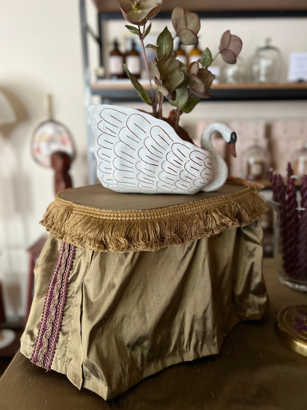 Decorative ceramic swan on a small table with a blurred background