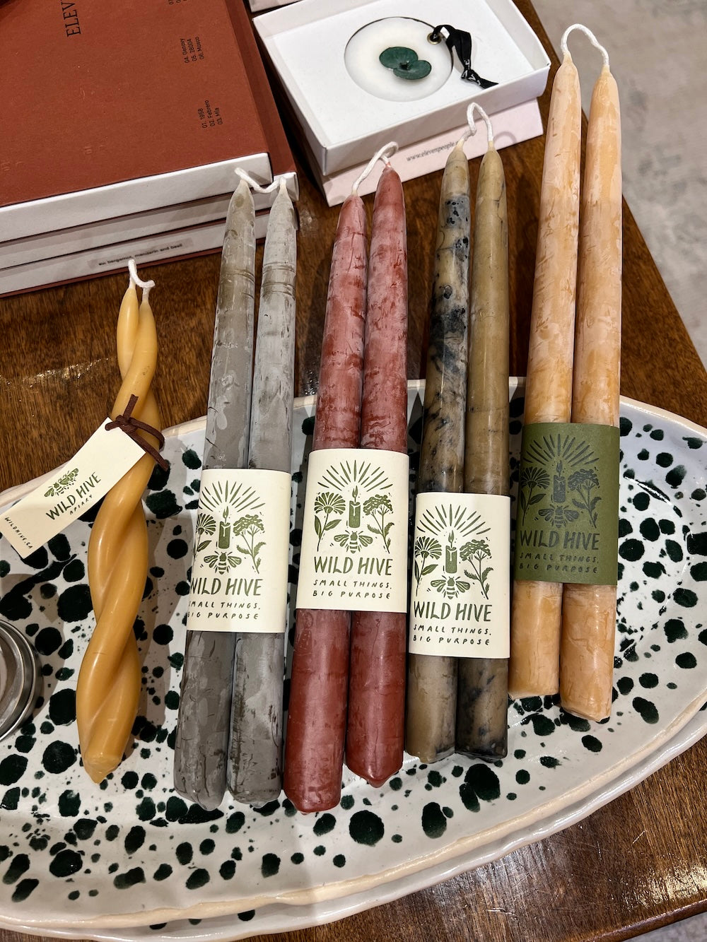 Four pairs of taper candles with 'Wild Hive' labels on a speckled tray.