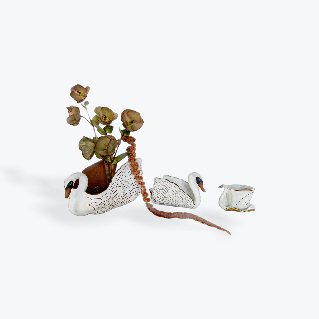Three ceramic swans on a white background