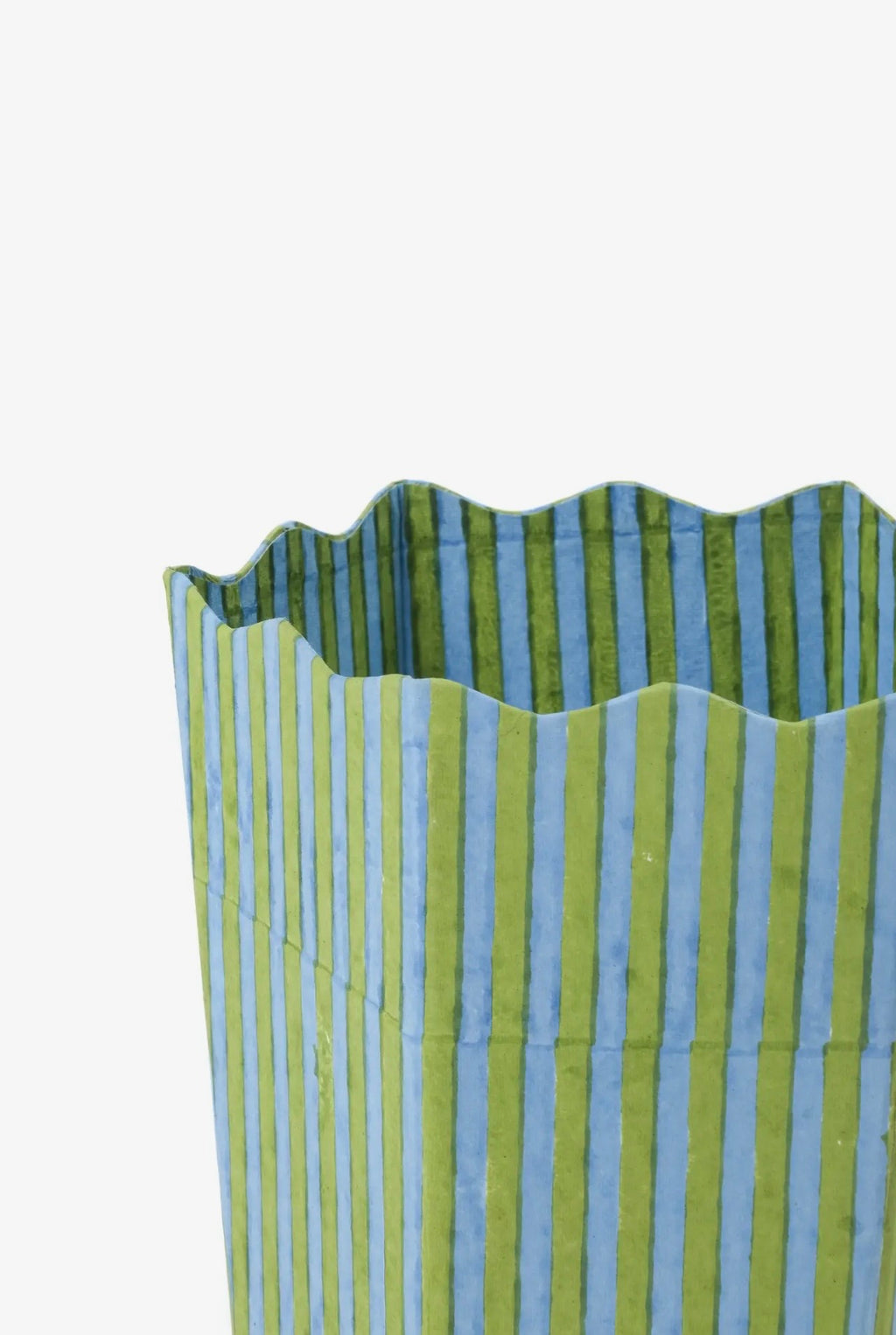 Detail of Green and blue striped bin with scalloped top on a white background